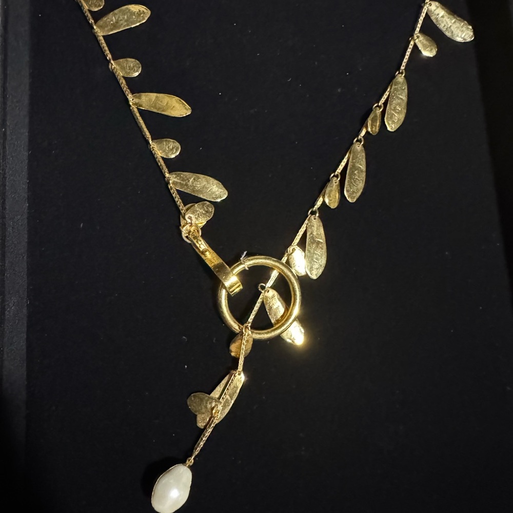 Lisner Gorgeous Gold tone Y-drop dainty necklace with shaped dangling charms.